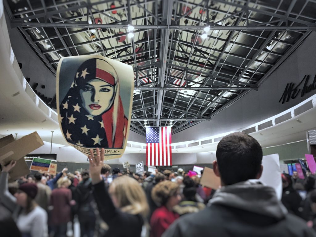 Image of Protest supporting Immigration centered on US Flag